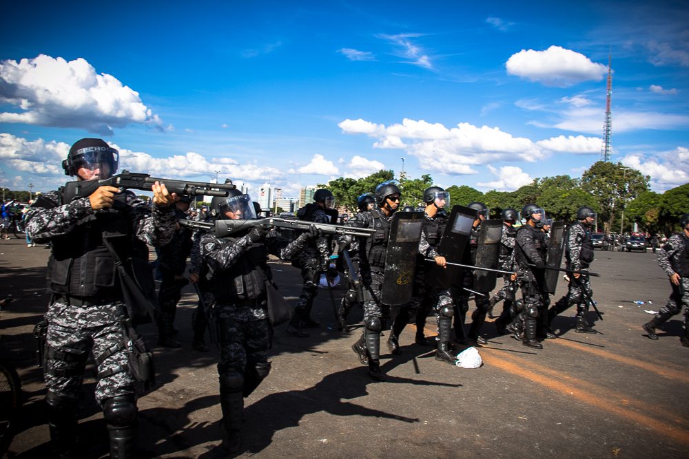 fotografia de grupo de policiais armados reprimindo manifestação