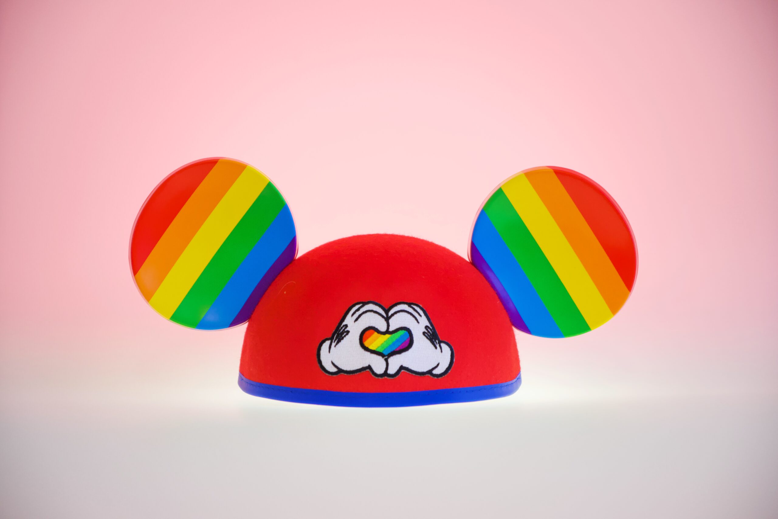 fotografia mostra modelo de orelhas do Mickey Mouse colorida com as cores do movimento LGBT
