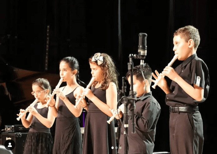 imagem mostra jovens músicos durante concerto