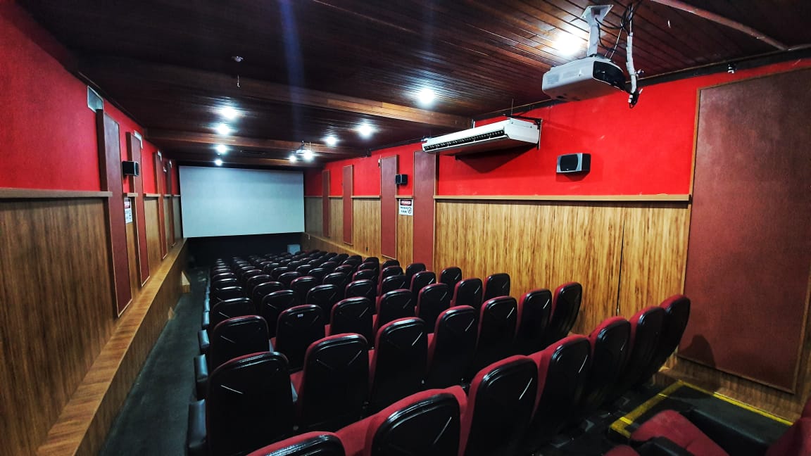 Sala de cinema do Cine Cultura, com poltronas e paredes vermelhas.