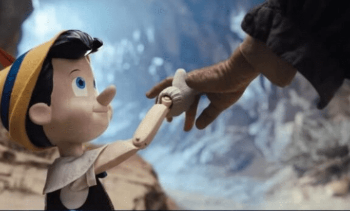 captura de tela do filme mais recente do Pinóquio mostra o personagem segurando uma mão humana