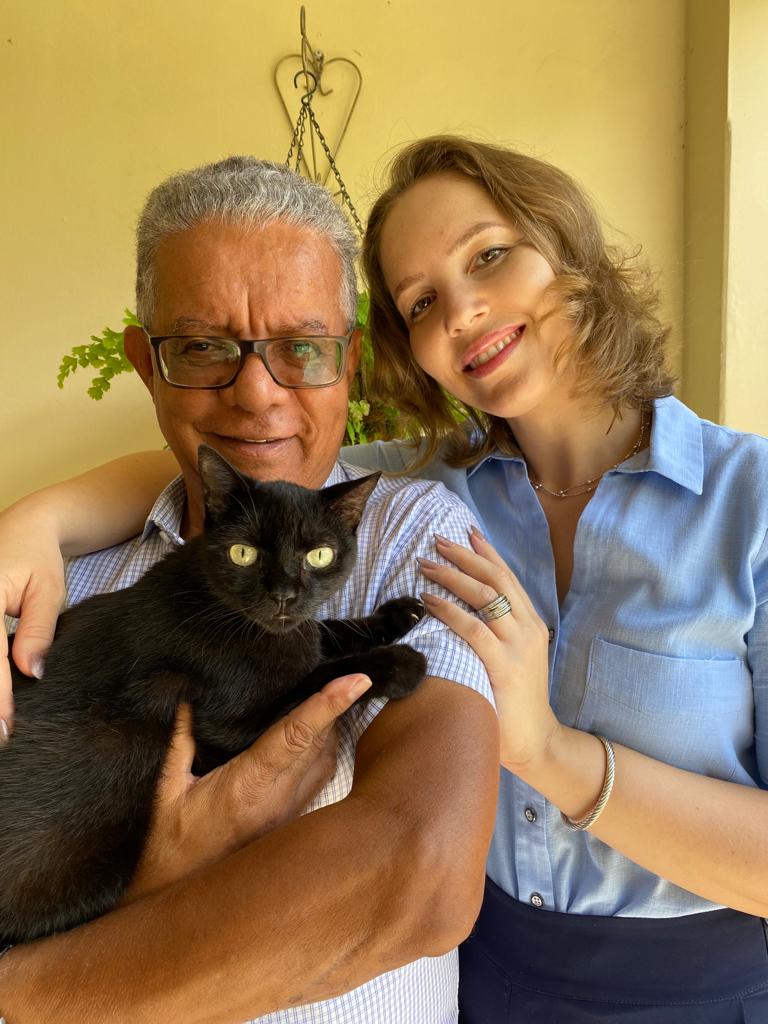 Gata preta chamada Sorte e seus tutores.