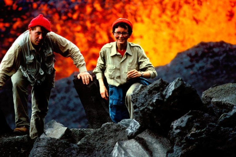 Maurice e Katia Krafft com explosões de lava ao fundo.
