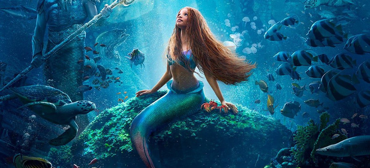 Imagem da atriz Halle Bailey, caracterizada de princesa Ariel, cercado por animais marinhos no fundo do mar.