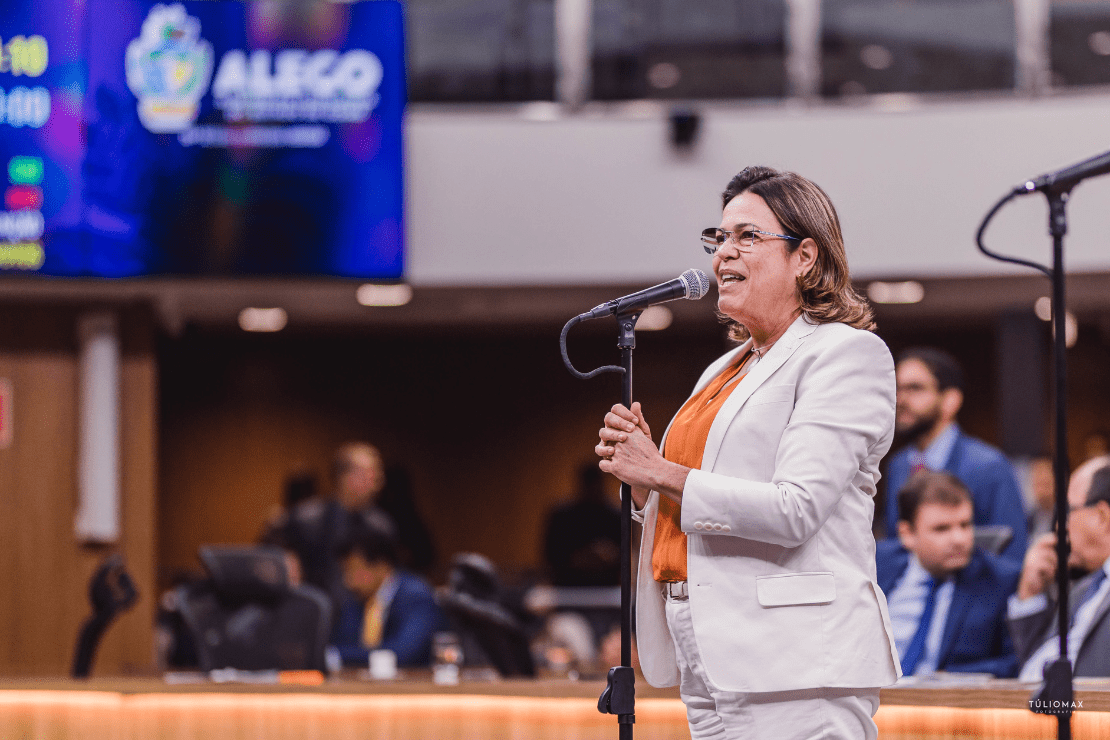Deputada Rosângela Rezende em frente a um microfone no plenário.