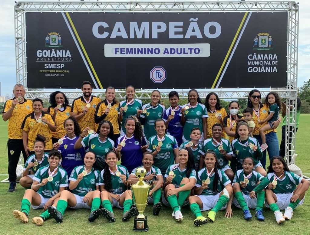 Na imagem está as atletas e comissão da diretoria do Aliança comemorando o título de campeão goiano