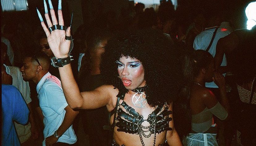 registro da festa mamba negra em são paulo pelo fotógrafo pedro pinho. há uma pessoa negra com a mão levantada e roupa de couro