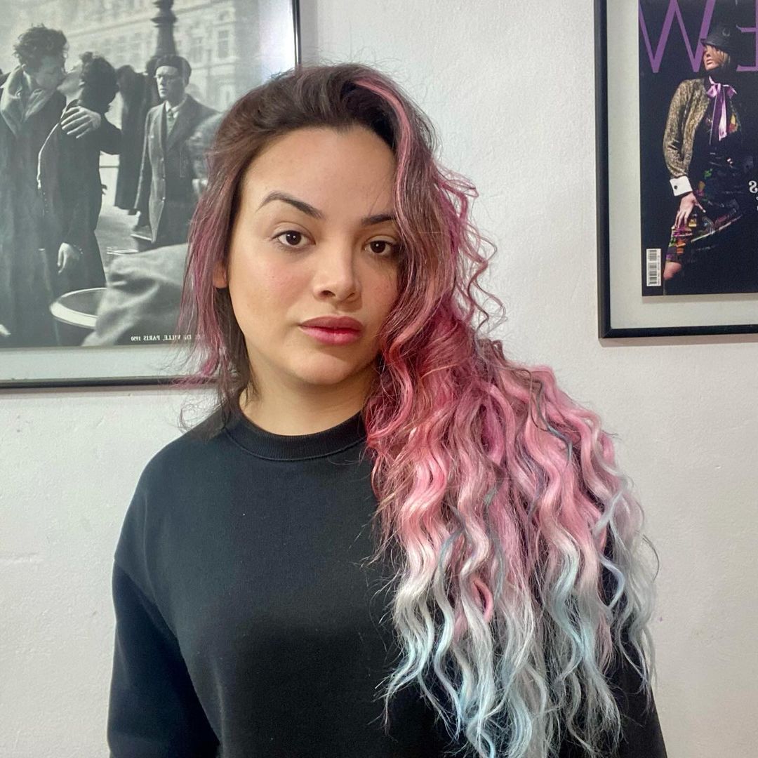 Anne Mota de longos cabelos ondulados rosa e azul, similar a um unicórnio, caracterizada para interpretar Alice Júnior.