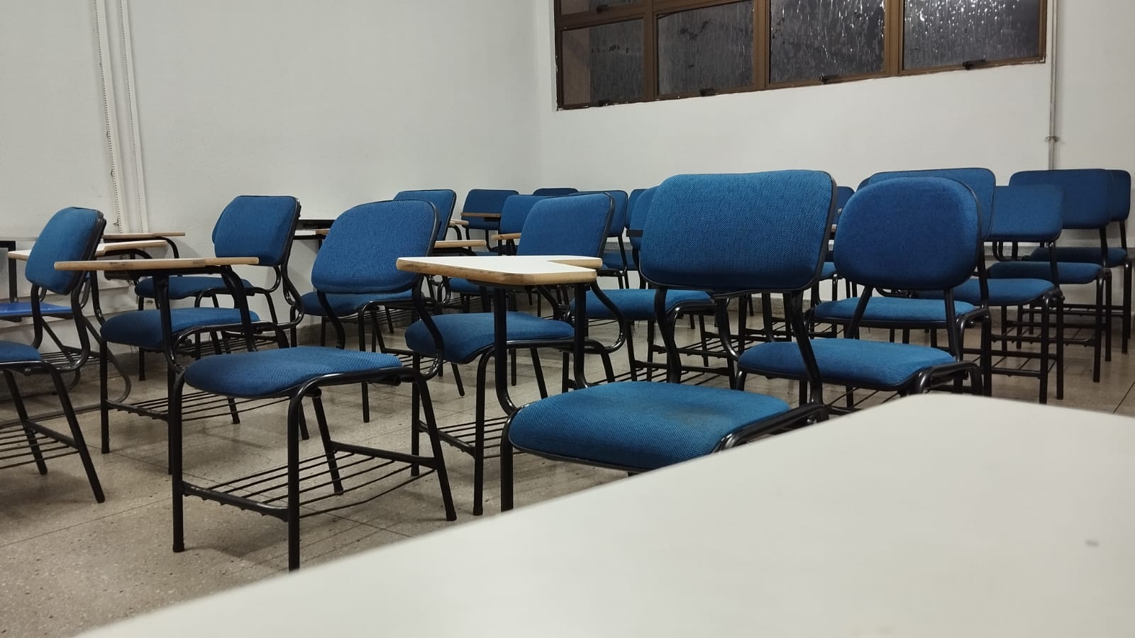 Sala de aula com cadeiras vazias.