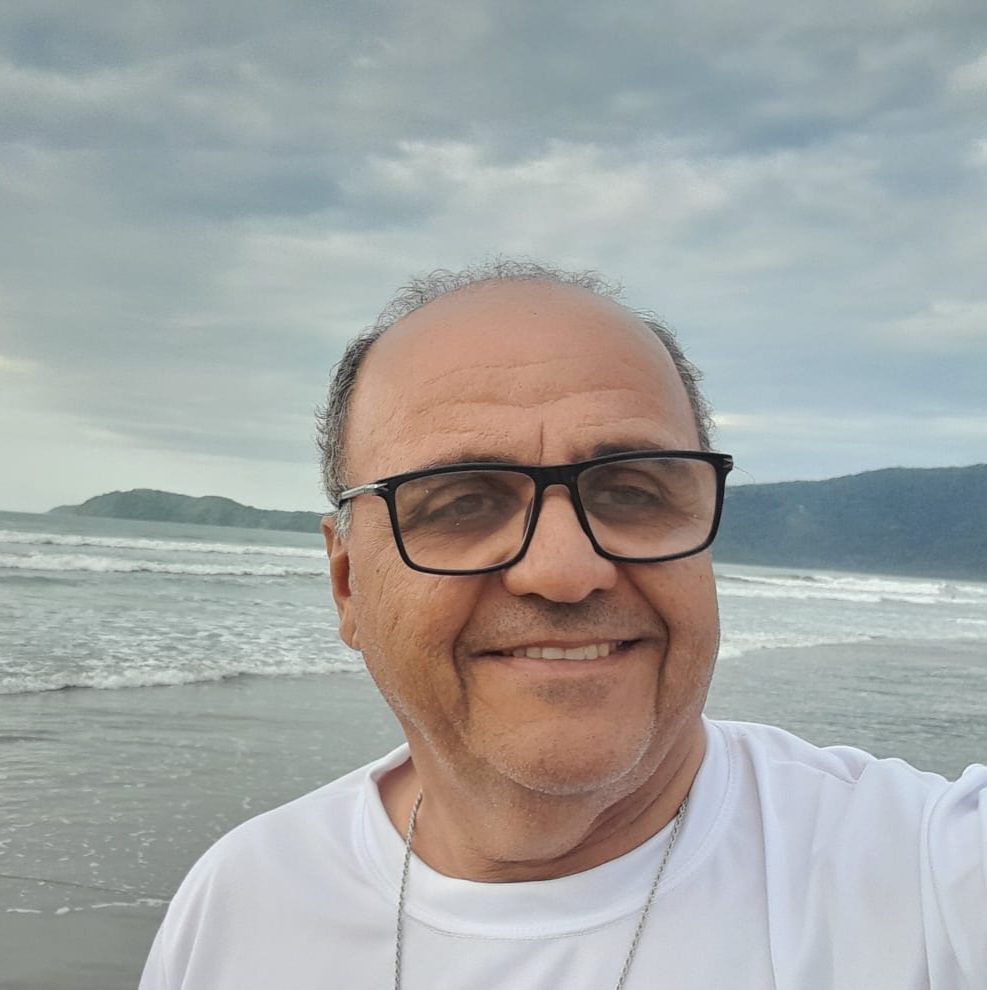 Foto Hamilton Amorim sorrindo de frente o mar.
