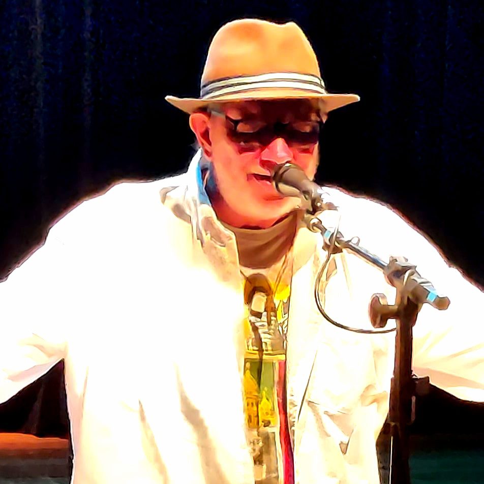 Fotografia de Xéxeu se apresentando em um palco, cantando em um microfone.