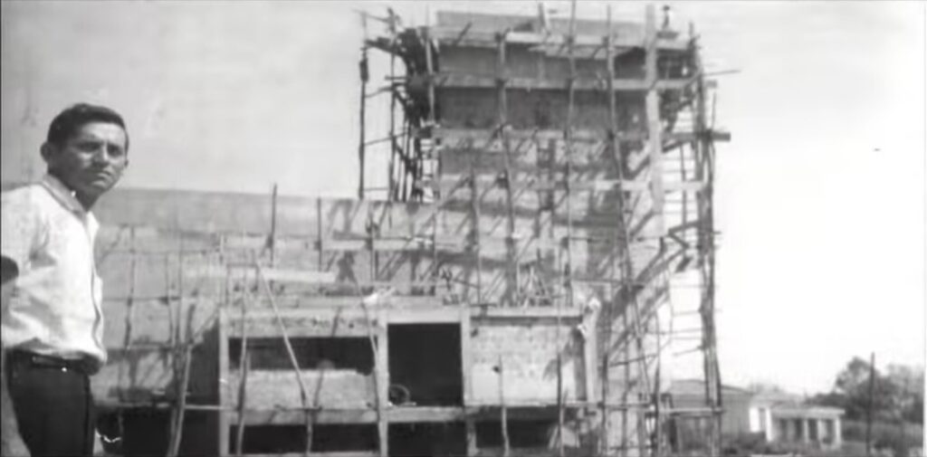 Octávio Arantes jovem, em pé ao lado da construção do Teatro InAcabado