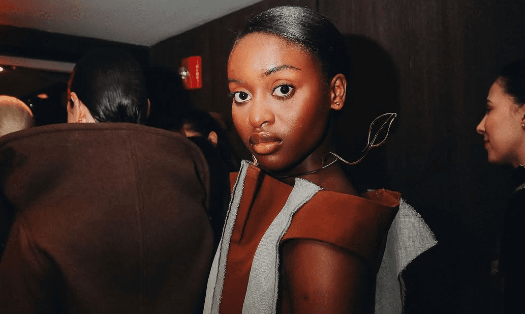 mulher negra com peça de roupa no backstage de um desfile