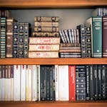 A detailed view of a bookshelf with vintage and classic books arranged neatly, offering a historic ambiance.